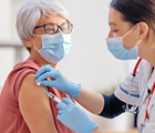 Doctor vaccinating a senior woman. Virus protection. COVID-2019.