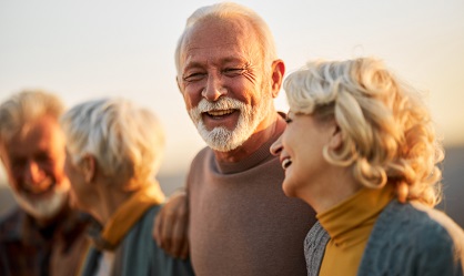 Happy senior man communicating with his friends while walking in autumn day.