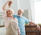 Selective focus of smiling senior couple dancing in kitchen